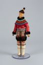 Image of West Greenland doll in costume, beaded collar, tall white boots, topknot